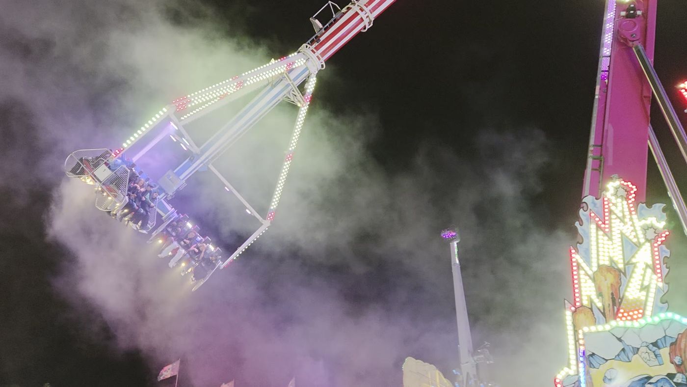 L'Infinity en plein looping, de nuit, dans la fumée et les lumières